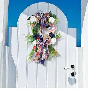 Corona de flores artificiales para el Día de la Independencia en una puerta blanca
