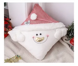 Detalle de una funda de cojín navideño con muñeco de nieve y gorro de Papá Noel rosa de felpa