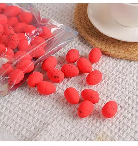 Gros plan de mini œufs de Pâques rouges tachetés sur un tissu blanc pour la décoration