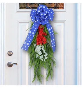 Independence Day wreath hanging on a classic white door with red and white flowers