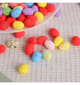 Mini œufs de Pâques tachetés de 2x2,5cm éparpillés sur un tissu blanc texturé