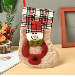 Detalle de un calcetín de Navidad de arpillera con un muñeco de nieve y borde de cuadros