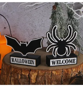 Détail de plaques en bois décoratives chauve-souris et araignée pour Halloween.
