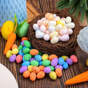 Mini œufs de Pâques colorés tachetés avec nid d'oiseau et accessoires carottes