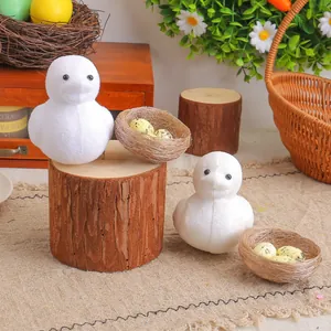 Paasdecoratieset met witte pluizige eendjes, vogelnesten en gespikkelde eieren.