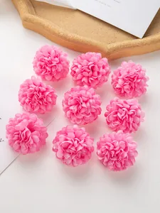 Vue de dessus de neuf têtes de chrysanthèmes en soie rose pour l'artisanat et le DIY.