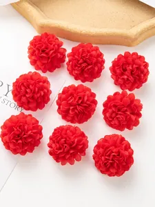 Gros plan de neuf têtes de chrysanthèmes artificiels en soie rouge pour loisirs créatifs.