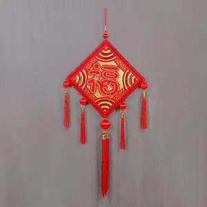 Detail view of a traditional Chinese Fu character pendant with long red tassels