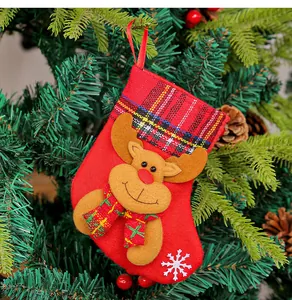 Detailweergave van een kleine rode kerstsok met rendierversiering aan de boom