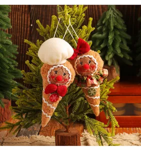 Gros plan de suspensions en tissu bonhomme de pain d'épices sur un sapin décoré.