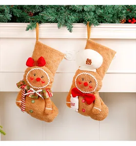 Détail des chaussettes de Noël bonhomme de pain d'épices sur une cheminée blanche