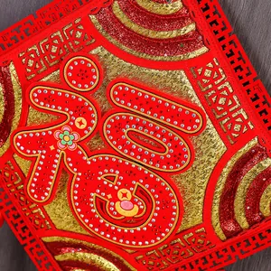 Macro detail of Chinese Fu character hanging ornament with rhinestones and gold texture