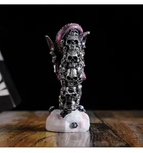 Detailed view of a gothic resin dragon sculpture with stacked skulls for Halloween decor.