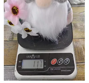 Weight measurement of an Easter faceless gnome plush doll with flowers on a scale, 117g