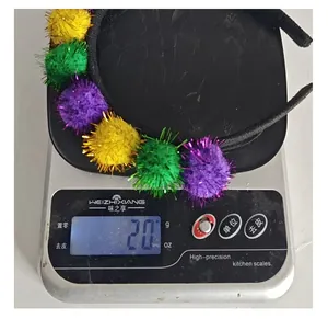 Detailfoto van een Mardi Gras pompon hoofdband die 20g weegt op een digitale weegschaal.
