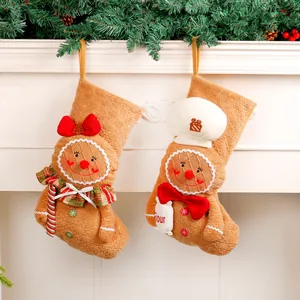 Paire de chaussettes de Noël en tissu bonhomme en pain d'épices sur un manteau de cheminée blanc