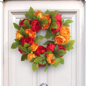Vibrant red and orange artificial peony flower wreath for home wall or wedding decoration.