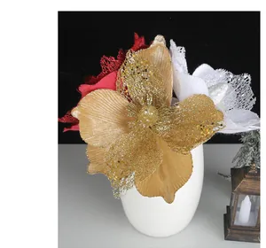 Detail view of glittered gold, red and white Christmas flowers in a white vase