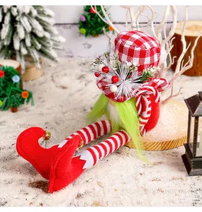 Close-up detail of a Christmas gnome doll with long legs and a green beard in snow scene
