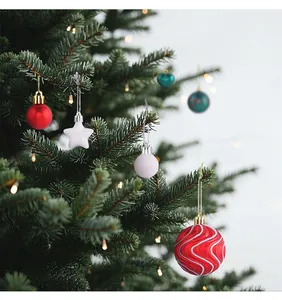 Detailansicht von festlichen roten und weißen Weihnachtskugeln an einem Tannenbaum