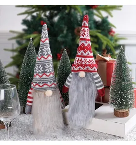 Vue détaillée de deux gnomes de Noël tricotés avec de longues barbes grises décoratives.