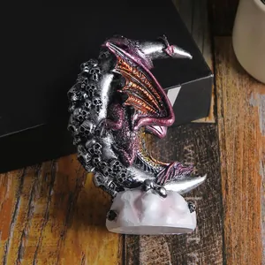 Detailed Gothic dragon perched on a skull-covered crescent moon resin statue for Halloween decor