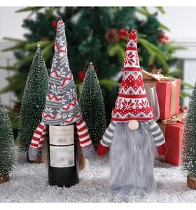 Deux protège-bouteilles de vin gnomes de Noël tricotés dans un décor de fête joyeux