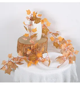 Detail view of artificial autumn ivy vines with orange maple leaves for Thanksgiving decoration