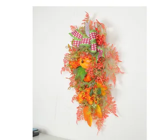 Close-up detail of autumn harvest door wreath featuring pumpkins and a checkered bow