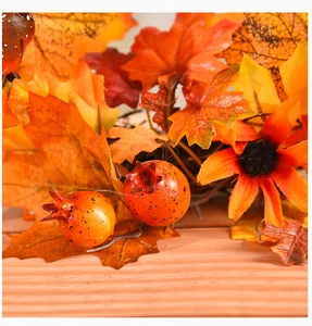 Macro detail of decorative autumn wreath featuring orange maple leaves and seasonal berries