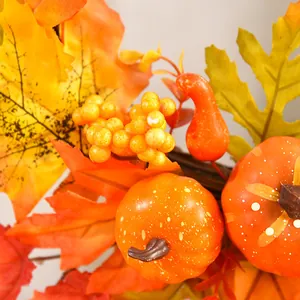 Autumn Halloween wreath detail with artificial pumpkins and maple leaves
