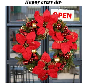 Close-up detail of a large red Christmas poinsettia wreath with festive gold ornaments
