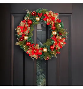 Large festive Christmas wreath with red poinsettias and ornaments on a dark door