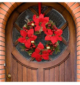 Large festive Christmas wreath with red poinsettia flowers hanging on a front door