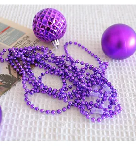 Détail macro d'une chaîne de perles en plastique violet et boules de Noël texturées