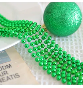 Gros plan d'une chaîne de perles en plastique vert brillant pour fête