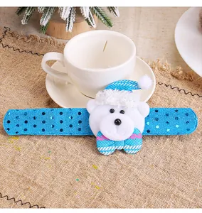 Détail d'un bracelet de Noël bleu à paillettes avec un motif d'ours en peluche festif