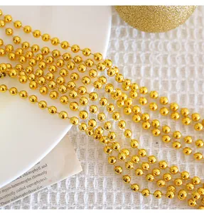 Détail de la chaîne de perles en plastique dorées brillantes pour décoration de Noël