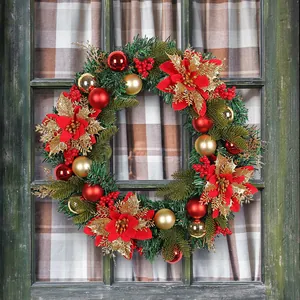 Large festive Christmas wreath with red poinsettias and gold ornaments on a rustic window
