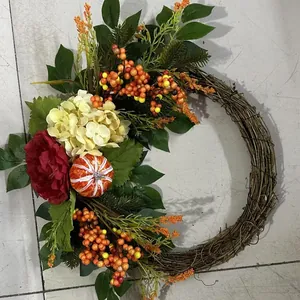 Detailed view of an autumn wreath with hydrangeas, pumpkin, and berries on grapevine.