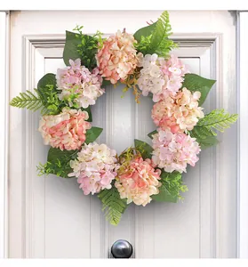 Detailed view of pink and cream artificial hydrangea wreath hanging on a white door