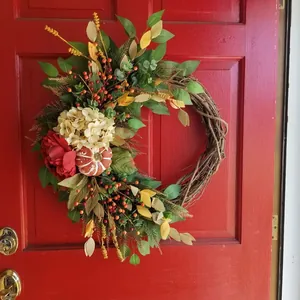 Rustic autumn wreath featuring red hydrangea and pumpkin on a natural grapevine base