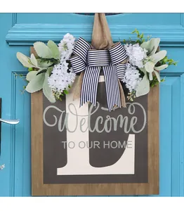Primo piano di targa in legno per porta con Welcome e decorazione floreale