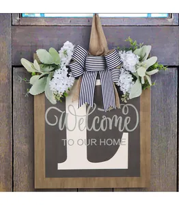 Close-up of personalized wooden door sign with letter L, striped bow and flowers