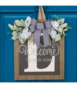 Dettaglio di targa per porta in legno personalizzata con lettera L e fiori bianchi