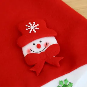 Close-up of a snowman patch with a red bow tie on a red brushed fabric Christmas hat.