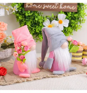 Detailed view of two plush gnomes holding colorful tulip bouquets for decoration