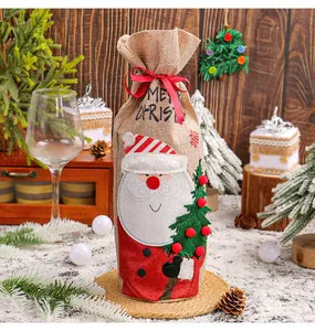 Close-up of burlap Christmas wine bottle bag with Santa Claus design and red ribbon