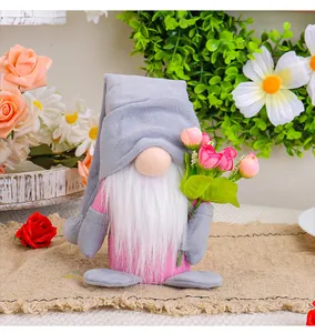 Detailed view of a pink and grey Rudolph gnome doll holding a bouquet of pink flowers.