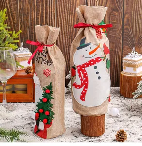 Macro view of Christmas burlap wine bottle bags featuring snowman and Santa applique.